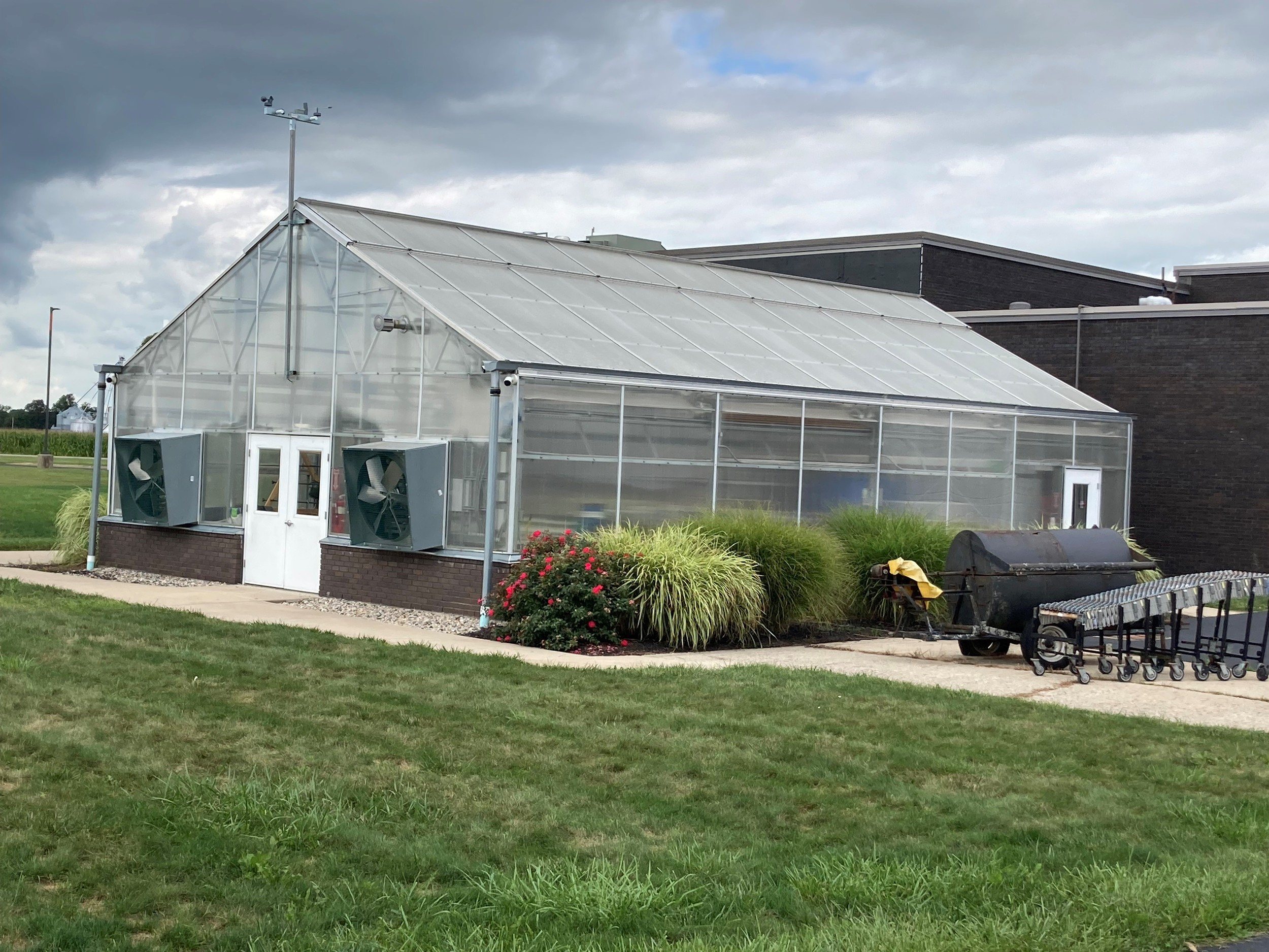 Traditional A-frame Vail greenhouse with a weather station and exhaust fans used for education.